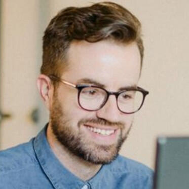 Nate Davenport smiling, gazing at computer screen